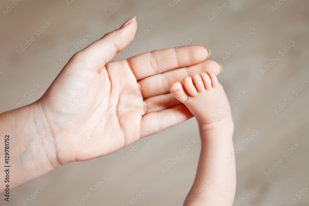 Baby feet in mother hands. Tiny Newborn Baby's feet on female Sh Baby feet in mother hands. Tiny Newborn Baby's feet on female Sh