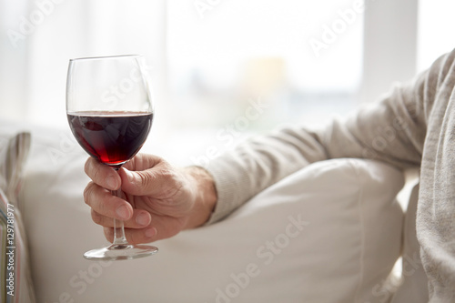 close up of hand holding glass with red wine photo