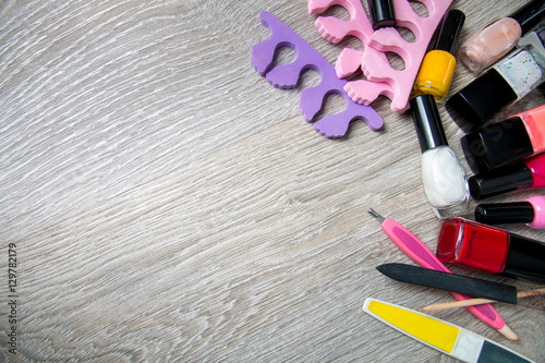 Set of nail polish and tools for manicure  pedicure  on a grey wooden background. Frame. Copy space. Top view. photo