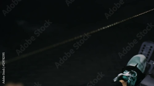 Beautiful girl athlete doing rowing crossfit exercises at the gym. Closeup chain
