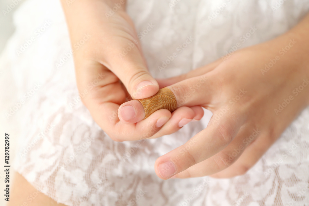 Close up view of little girl's finger with applied sticking plaster Close up view of little girl's finger with applied sticking plaster