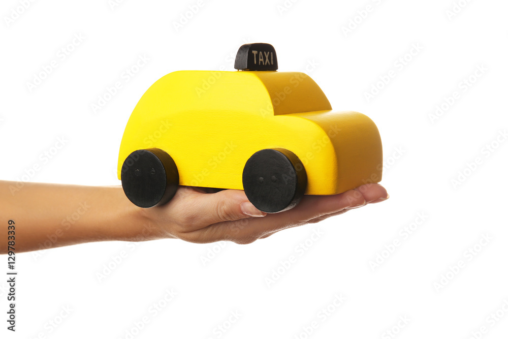 Woman holding yellow toy taxi on white background