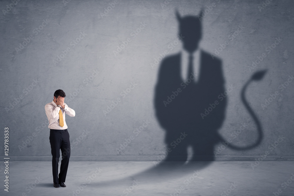 Fototapeta premium Business man looking at his own devil demon shadow concept