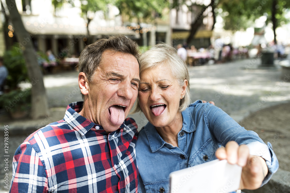 Senior couple pulling funny faces while taking selfie with smartphone Senior couple pulling funny faces while taking selfie with smartphone