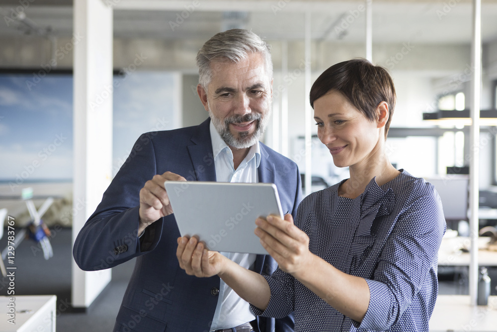 Businessman and businesswoman with tablet in office Businessman and businesswoman with tablet in office