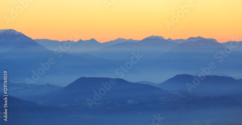 Colorful dusk in the French mountains, with the valley filled with fog. © sanderstock