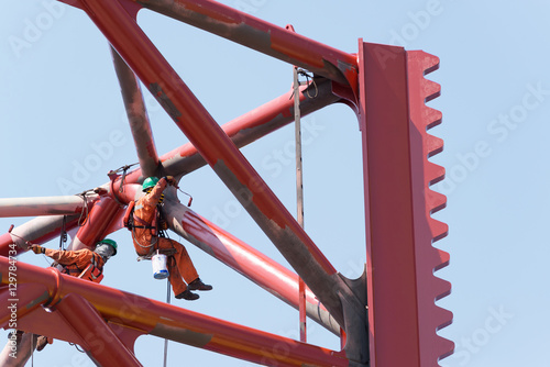 Workers working at height to paint the jack up oil and gas rig