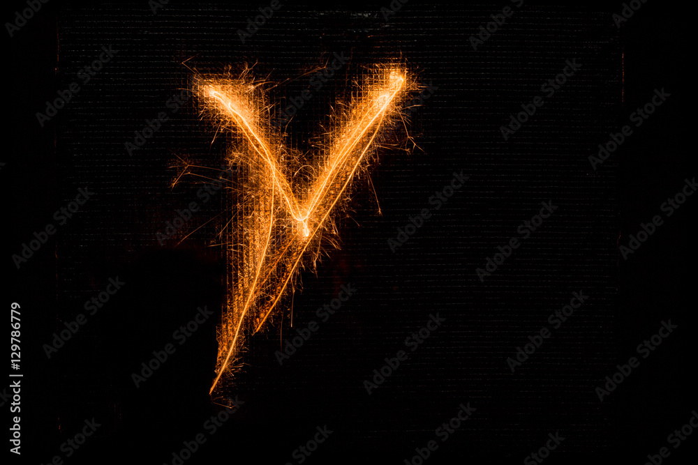 Letter V made of sparklers on black