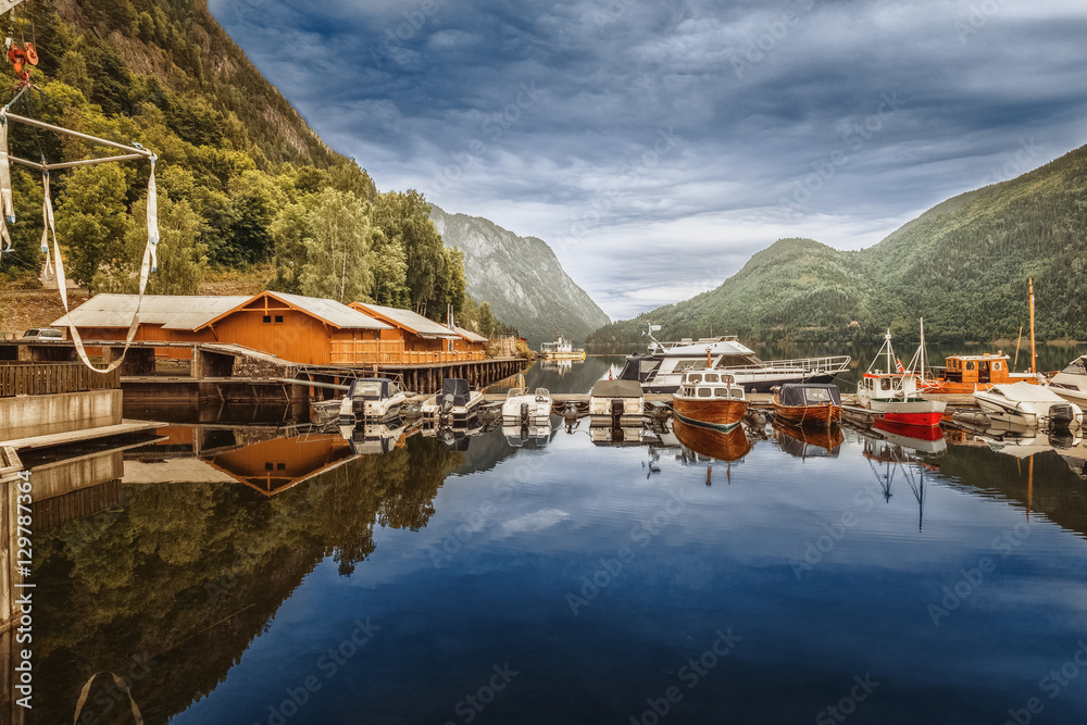 Boat berth on lake in Norway wild nature landscape. Location nearby fishing village.