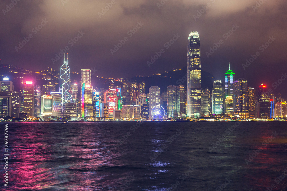Fototapeta premium Skyline night view of tall buildings from across Victoria Harbor