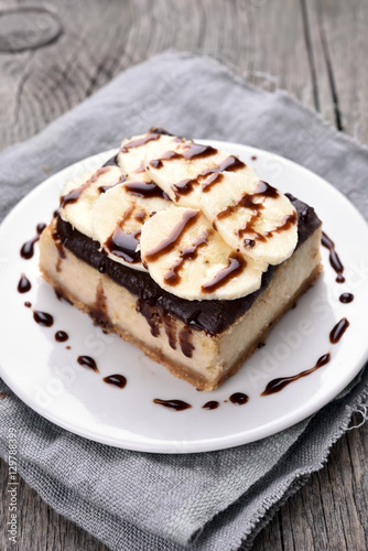 Cheese cake with chocolate syrup and piece of banana