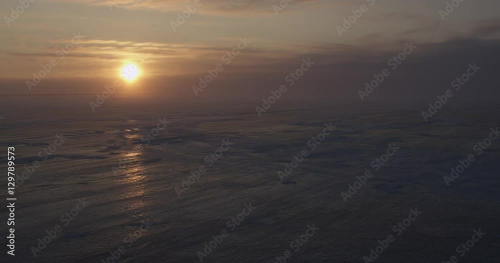 Sun shines off sea ice in blowing snow and storm clouds Sun shines off sea ice in blowing snow and storm clouds
