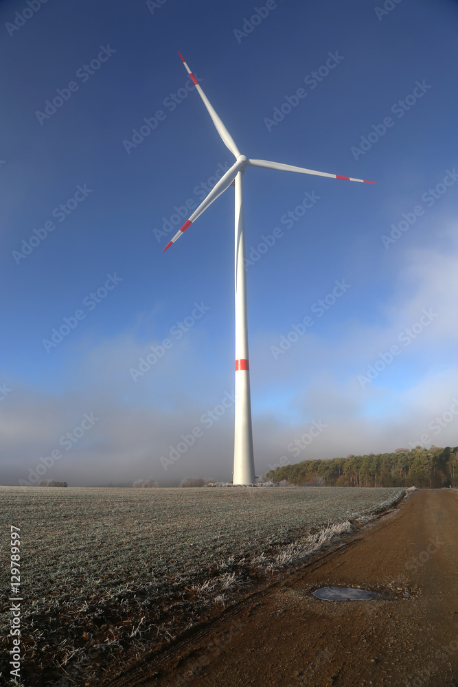 Windmill generator in wide yard / Yard of windmill power generatorunder blue sky, shown as energy industry concept