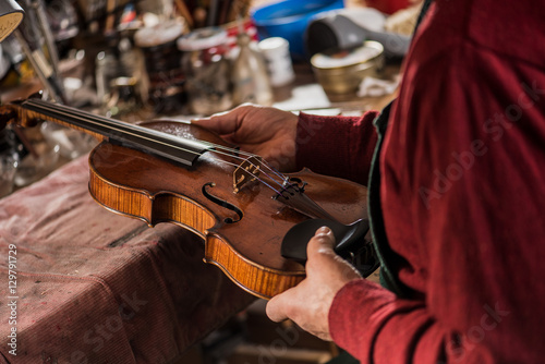 violin maker inspecting a violin photo