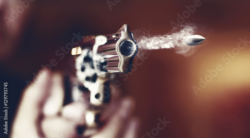 Fotografering hand gun revolver with flying bullet fire