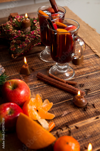 Mulled wine with fruits and spices on wooden table. Christmas. Winter warming drink recipe ingredients around.