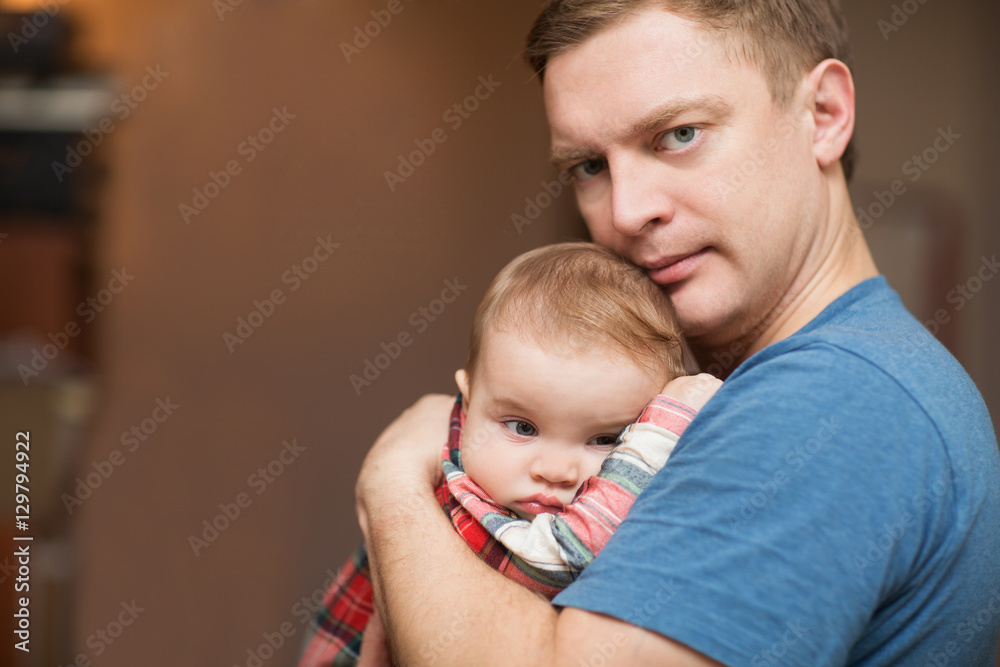 The father holds on hands of the little sad baby. Family concept. At the baby teeth are cut.
The father holds on hands of the little sad baby. Family concept. At the baby teeth are cut.