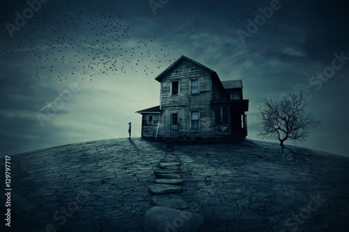 Home Return. Young man stand at the corner of a ravaged house, looking far away for someone. A ghost, desolated house with a dry land and tree. 
