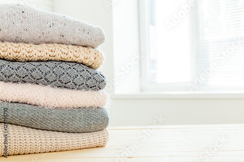 Stack of white cozy knitted sweaters