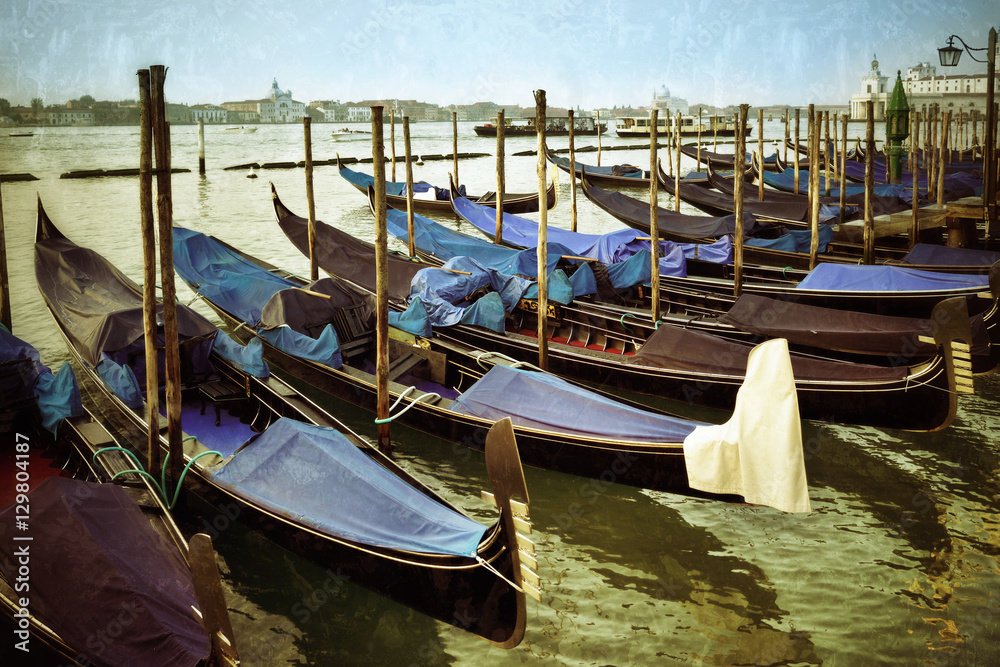 Gondolas moored by Saint Mark square at sunrise. Venice, Italy. Filtered image, vintage effect applied
