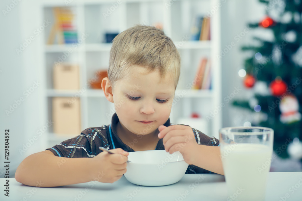 Little boy eating breakfast on the eve of the new year.