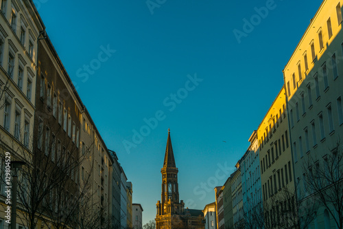 street with apartment buildings on both sides and church in the middle © Robert Herhold