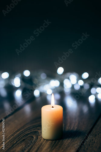 Burning candle on a table with Christmas decorations