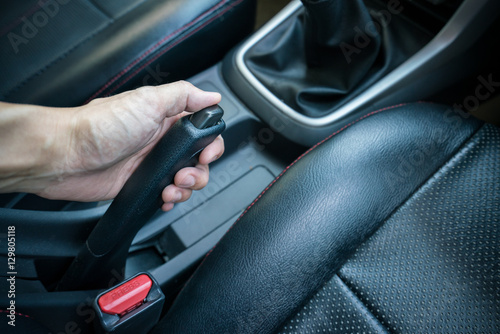 Hand pulling the hand brake in car - car interior, Focus on hand break © KissShot