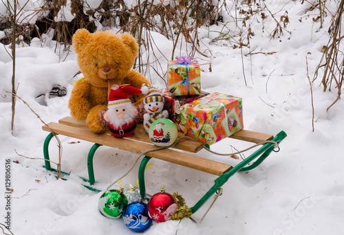 Новый год. Снежный лес. Рождество. Новогодние подарки. Игрушки и подарки в зимнем лесу. Игрушки на санках. Игрушечный мишка. Снеговик и санта клаус.
