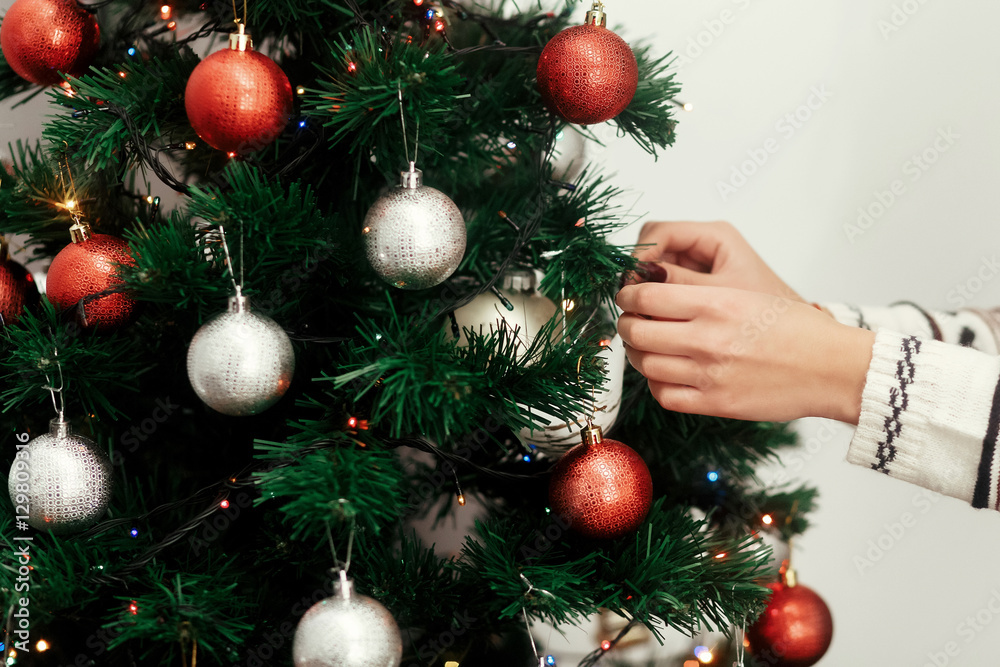 Fototapeta premium Beautiful woman in white stylish, winter sweater decorating chri