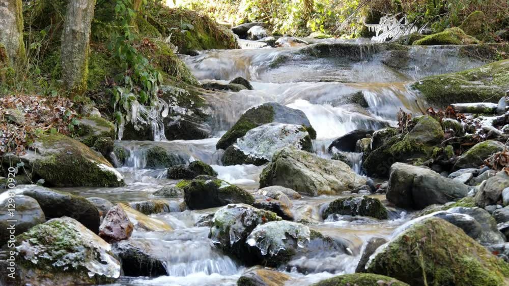 Beautiful brook flowing over rocks in winter time Beautiful brook flowing over rocks in winter time