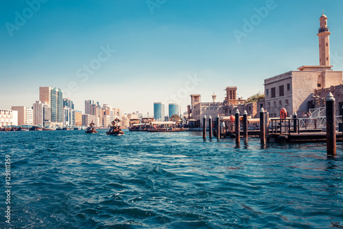 Skyline view of Dubai Creek with traditional boats and piers. Sunny summer day. Famous tourist destination in UAE. © oleg_p_100