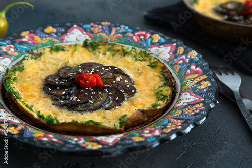 tasty omelet or badimjan chihirtmasi with eggplant, red onion and peper sprinkled parsley on beautiful traditional plate, Azerbaijan