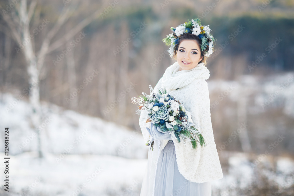 Bride with bouquet looking at the camera. Bride in the Park in winter. Bride with bouquet looking at the camera. Bride in the Park in winter.