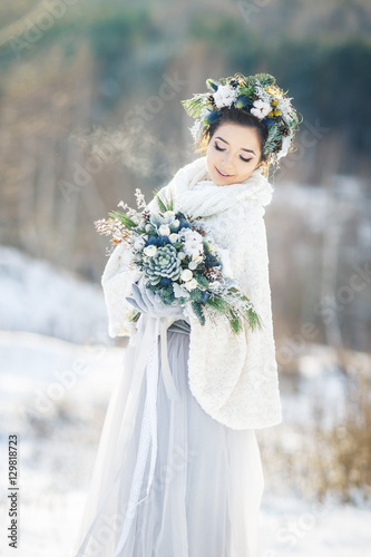 Cute bride with a bouquet. Winter wedding bouquet.