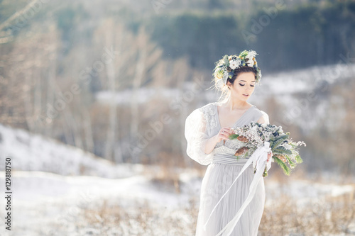 Beautiful bride admiring wedding bouquet. Winter wedding. Winter wedding bouquet.