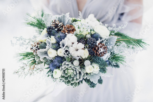 Winter wedding bouquet in hands of bride.