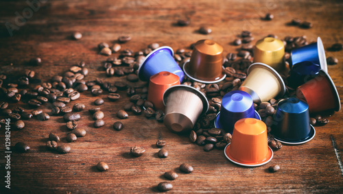 Colorful espresso capsules on wooden background photo
