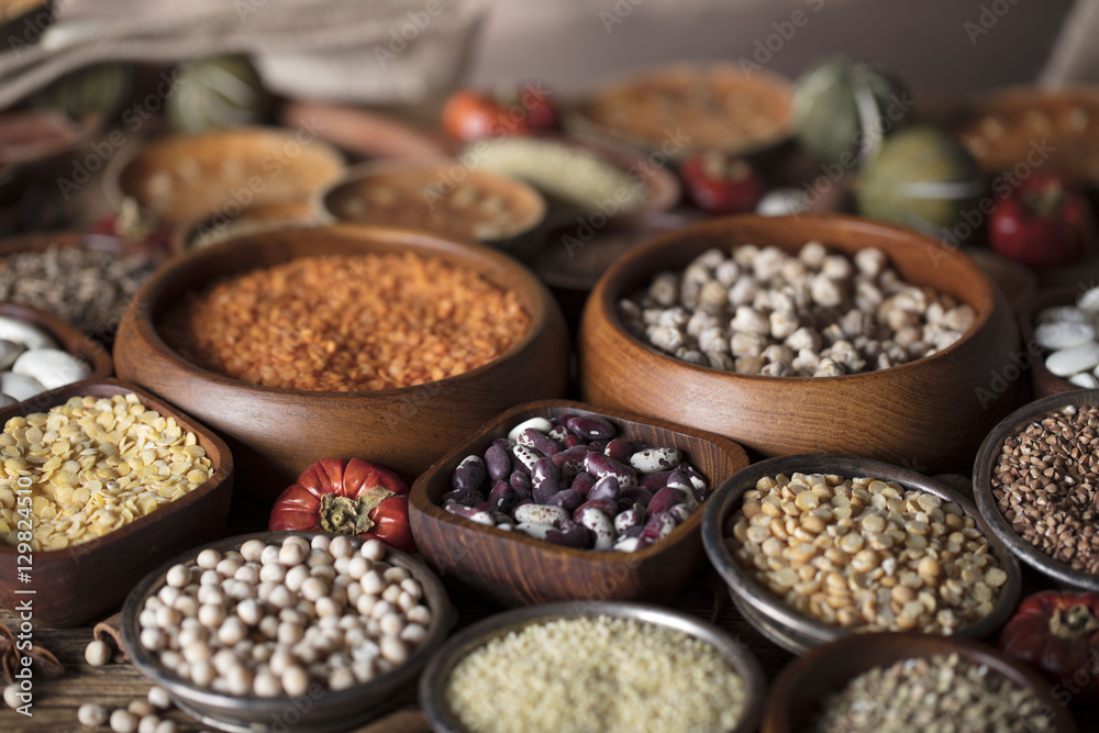 Fototapeta premium Healthy food and diet theme. Lentils, peas, beans, protein food in bowls, on a wooden table.