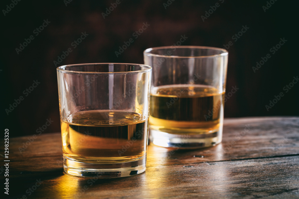Glasses of whiskey on a wooden table Glasses of whiskey on a wooden table
