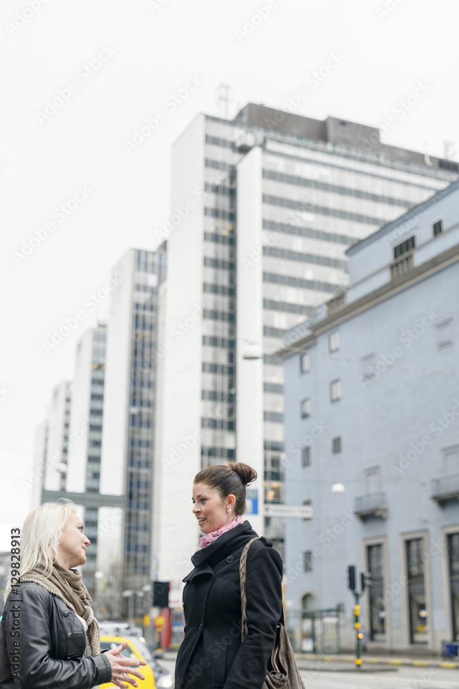 Sweden, Stockholm, Mid adult women talking in street Sweden, Stockholm, Mid adult women talking in street