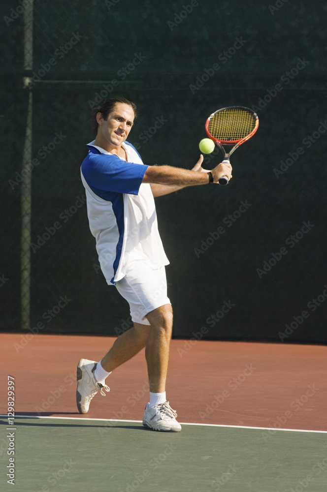 Full length of a mid adult man playing tennis