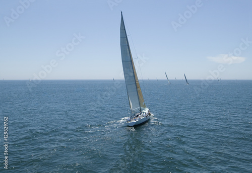 Overview of sailboats racing in the blue and calm ocean against sky © moodboard