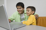 Father and Son at desk Using Laptop close up