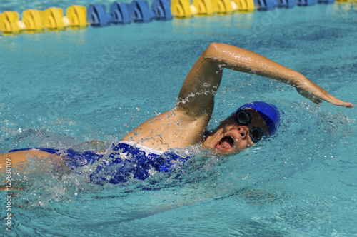 Competitive athlete swims a freestyle stroke during a pool race