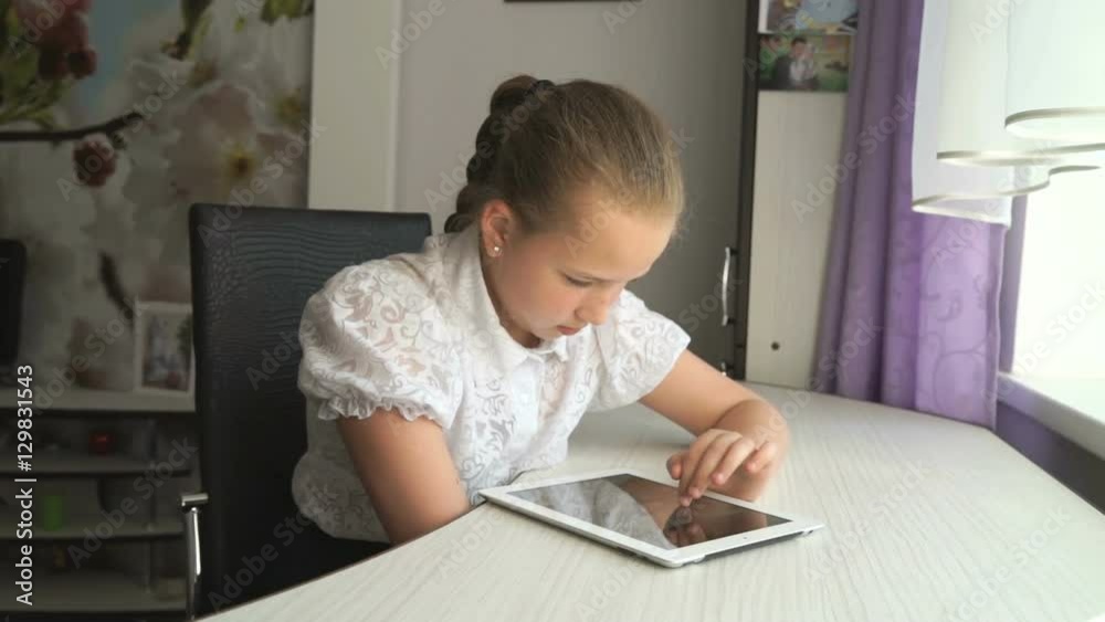 Teenager girl working a digital tablet computer at home Teenager girl working a digital tablet computer at home