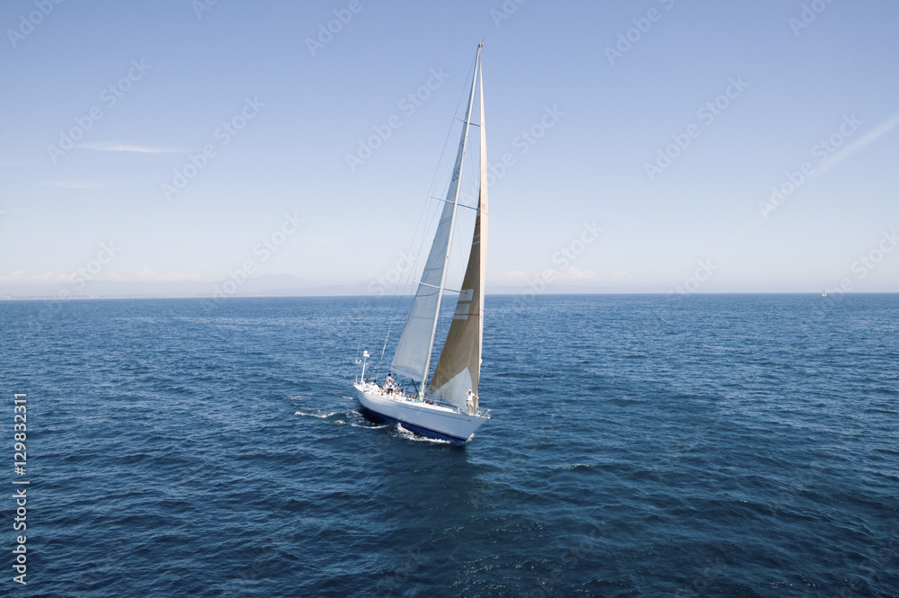 Sailboat at the peaceful blue ocean against the sky