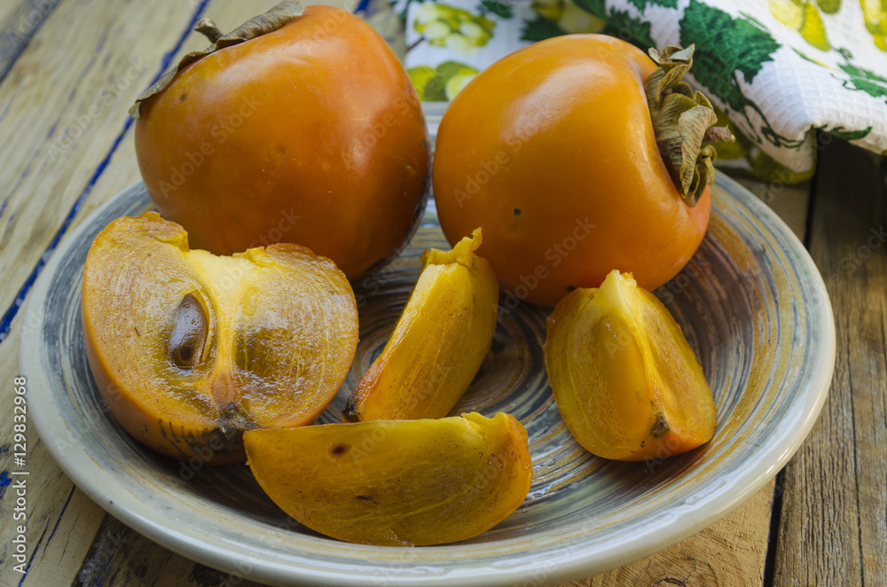 ripe persimmon on a plate ripe persimmon on a plate