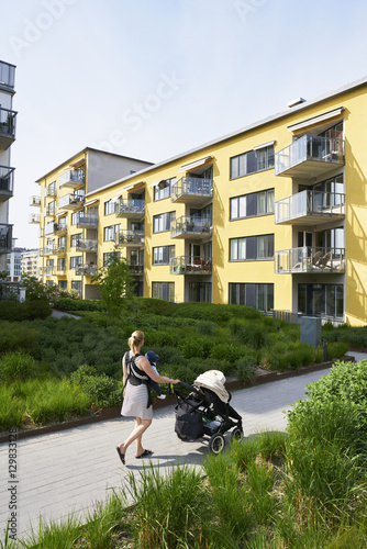 Sweden. Sodermanland, Hammarby Sjostad, Woman pushing baby carriage photo