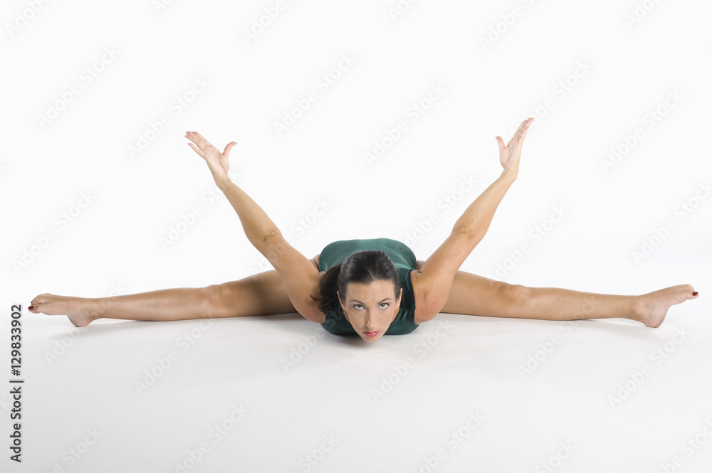 Fototapeta premium Portrait of mid adult woman exercising over white background